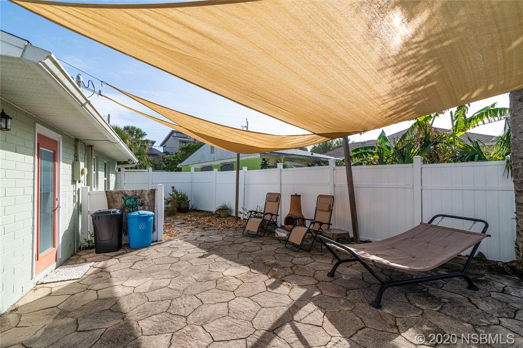 405 Tide Street New Smyrna Beach, FL 32169 - Photo 20 of 33 a backyard of a house with outdoor seating