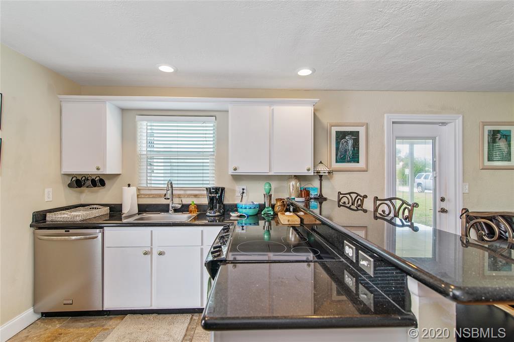 405 Tide Street New Smyrna Beach, FL 32169 - Photo 8 of 33 a kitchen with a sink stove and cabinets