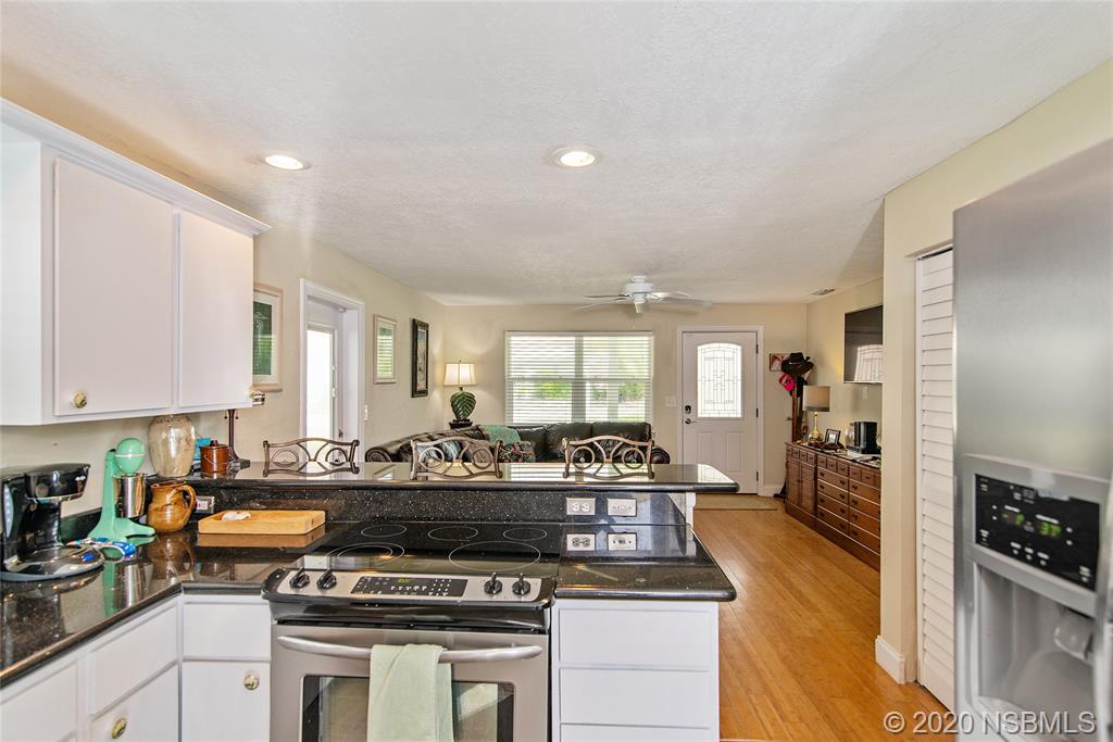405 Tide Street New Smyrna Beach, FL 32169 - Photo 9 of 33 a kitchen with a stove and a sink