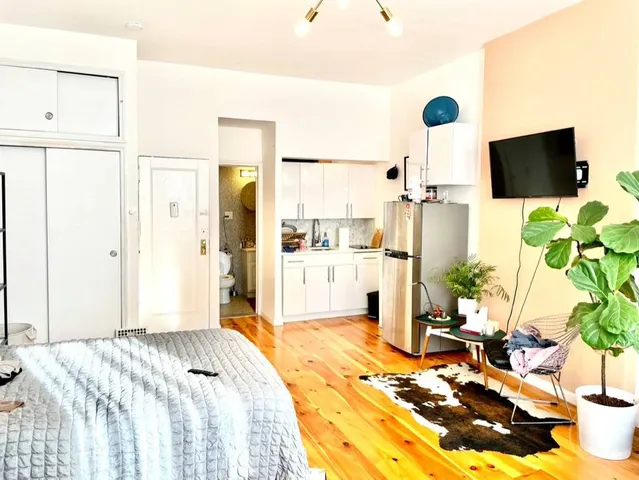 a bedroom with a bed potted plant and a large window
