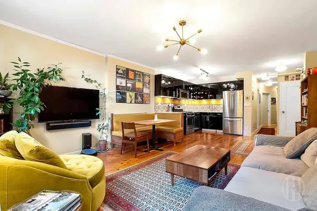 a kitchen with stainless steel appliances kitchen island granite countertop a sink stove and view of living room