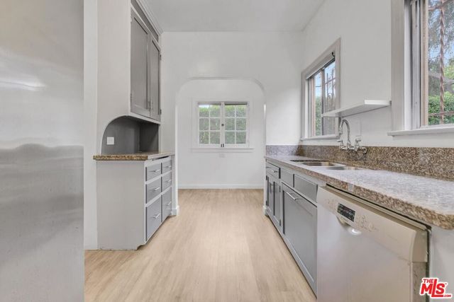 a kitchen with granite countertop a sink stove and cabinets