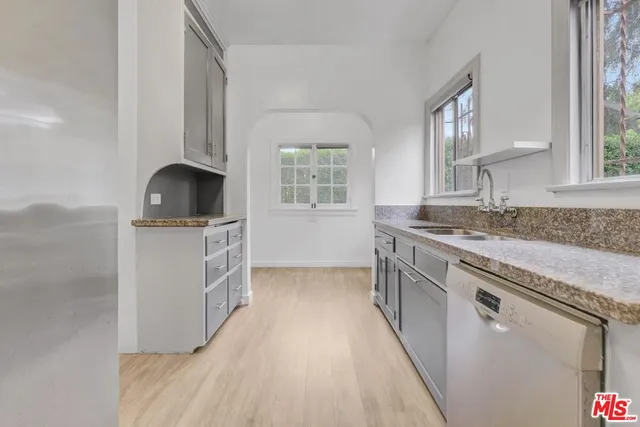 a kitchen with granite countertop a sink stove and cabinets