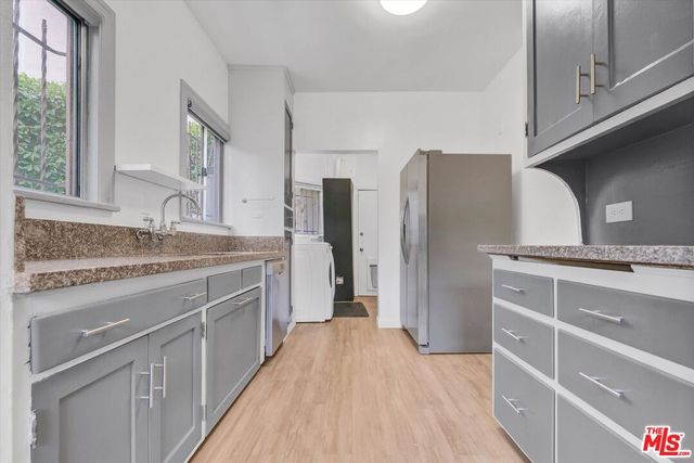 a kitchen with stainless steel appliances granite countertop a sink and refrigerator