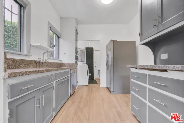 a kitchen with stainless steel appliances granite countertop a sink and refrigerator