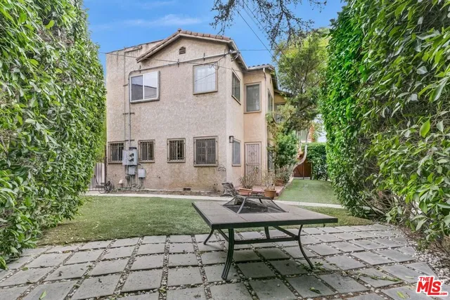a view of a brick house with a bench and a yard