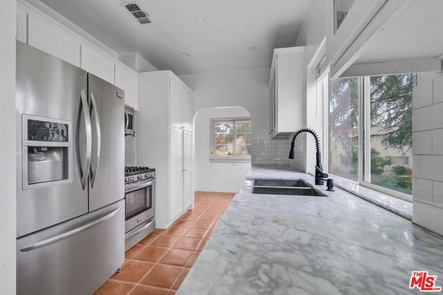 a room with stainless steel appliances a refrigerator and a stove