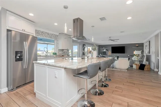 a large kitchen with stainless steel appliances kitchen island granite countertop a large counter top and a stove