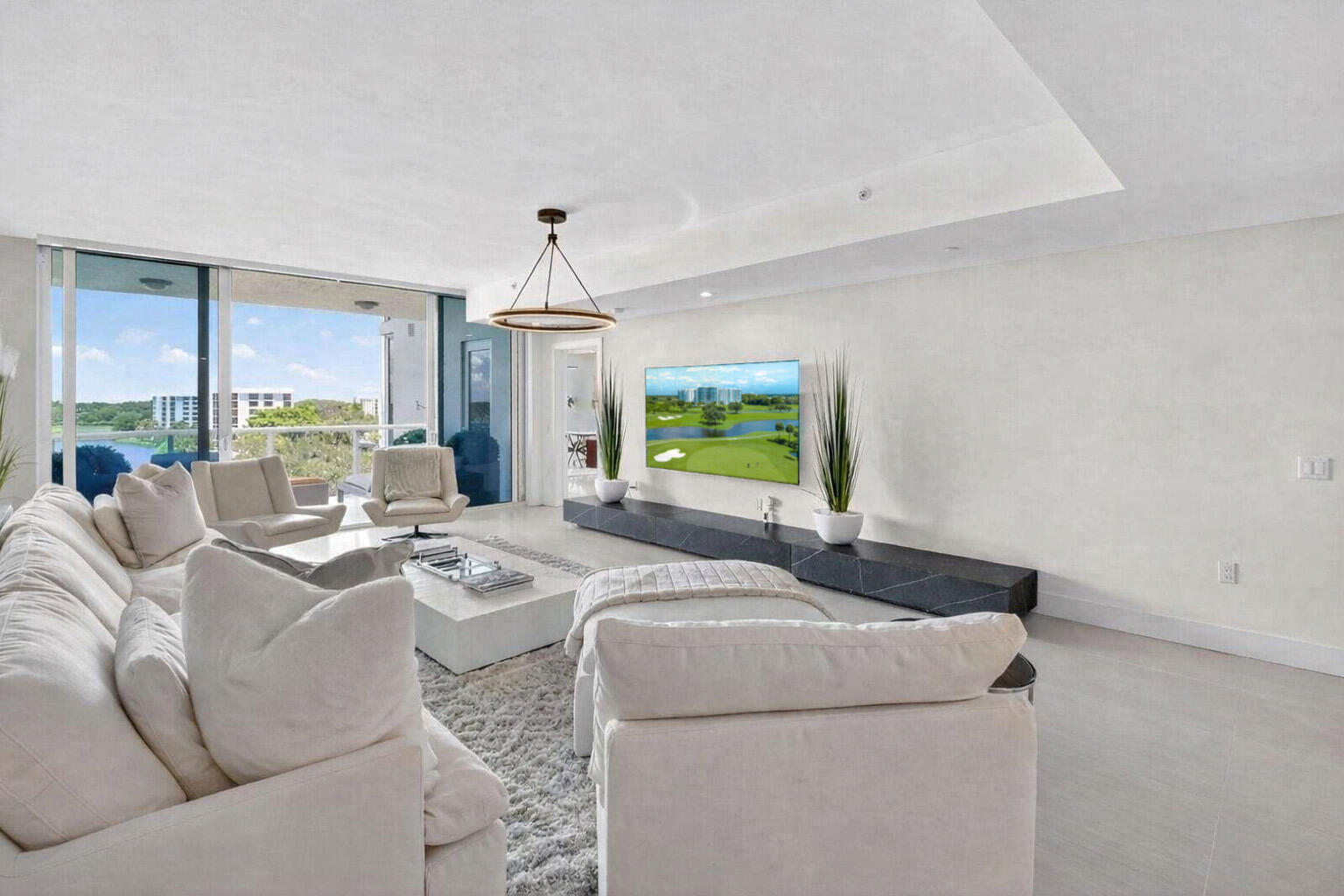 20155 Boca W Drive, Unit C504 Boca Raton, FL 33434 - Photo 2 of 42 a living room with furniture a window and a chandelier