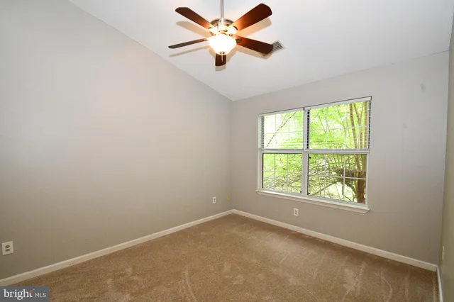an empty room with a window and a fan