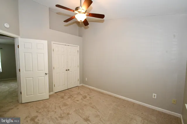 an empty room with a ceiling fan and a fan