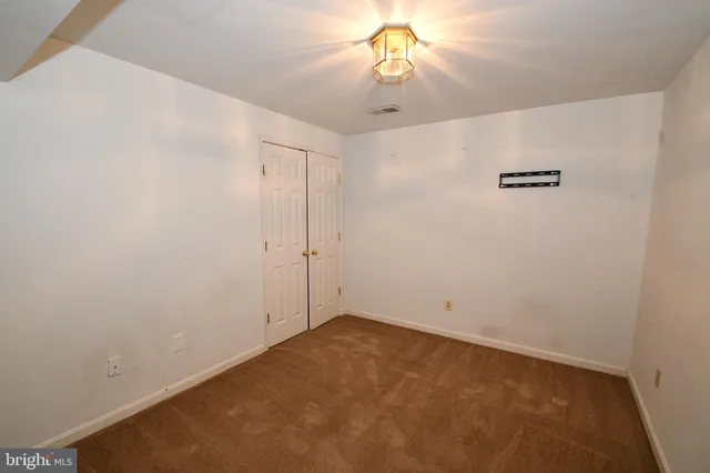 an empty room with a fan & a ceiling fan