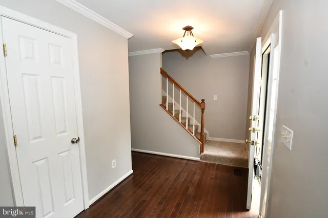 a view of a hallway with wooden floor and staircase
