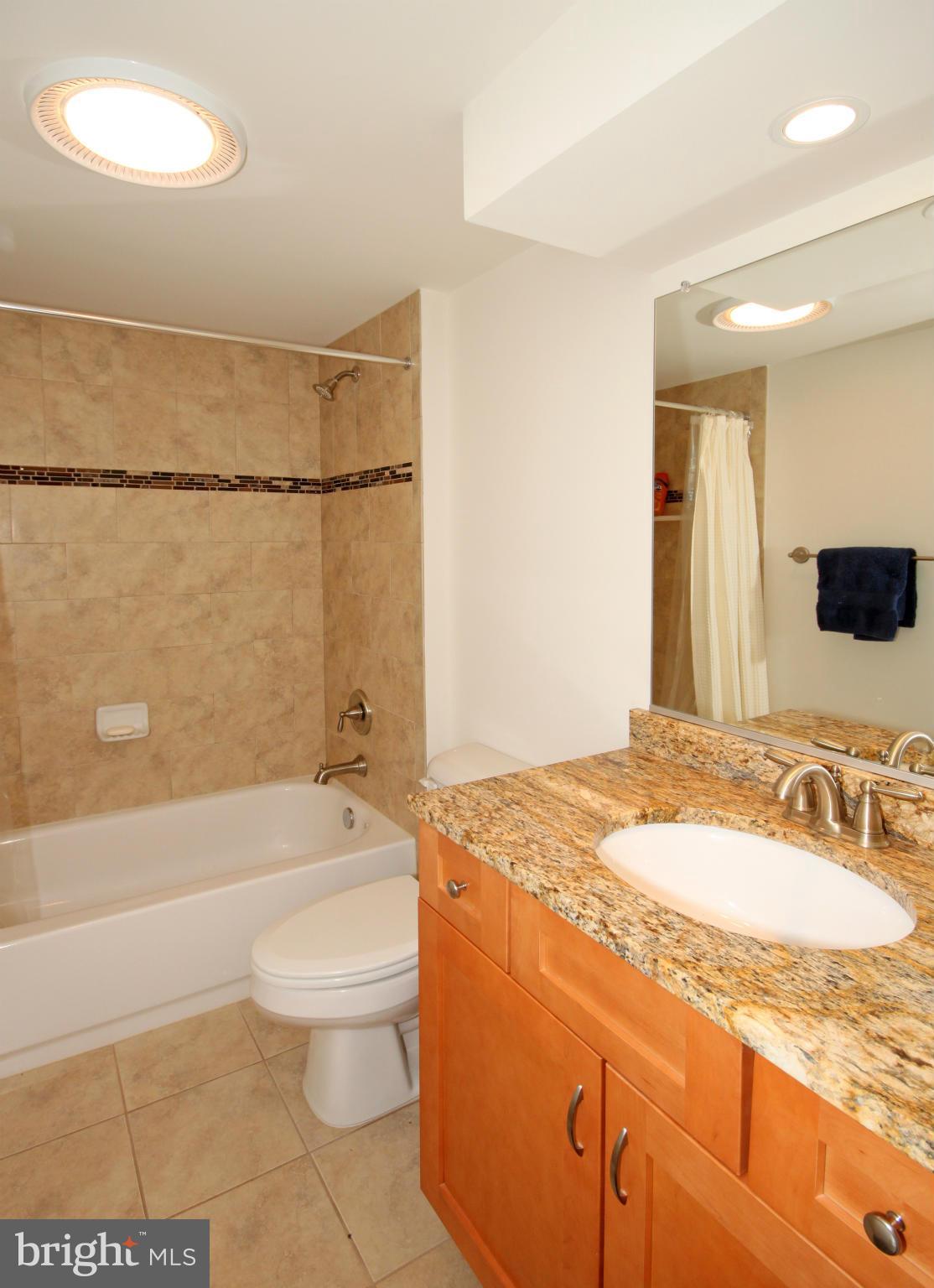 5420 Inverchapel Road Springfield, VA 22151 - Photo 23 of 29 a bathroom with a granite countertop sink toilet mirror and bathtub