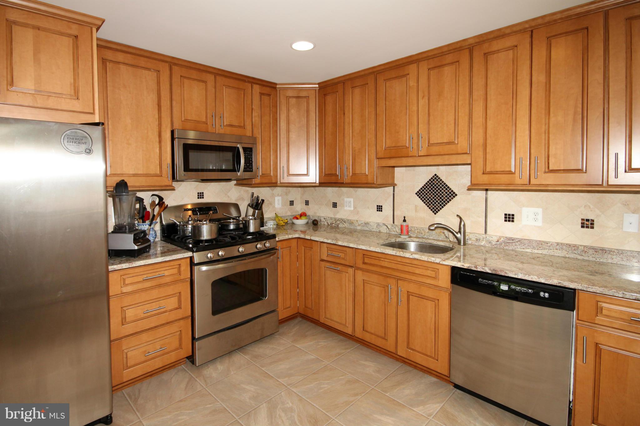5420 Inverchapel Road Springfield, VA 22151 - Photo 8 of 29 a kitchen with granite countertop wooden cabinets and stainless steel appliances