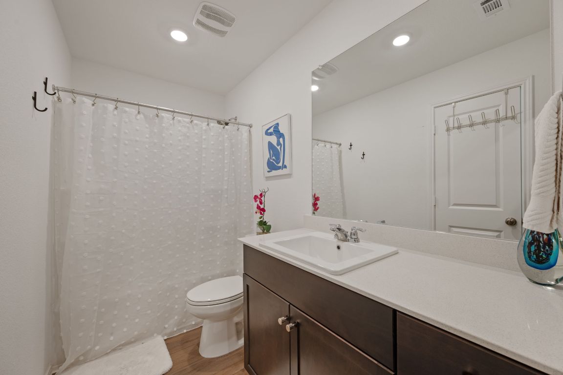 68 Trinity Circle Lockhart, TX 78644 - Photo 17 of 27 a bathroom with a sink a toilet and a large mirror