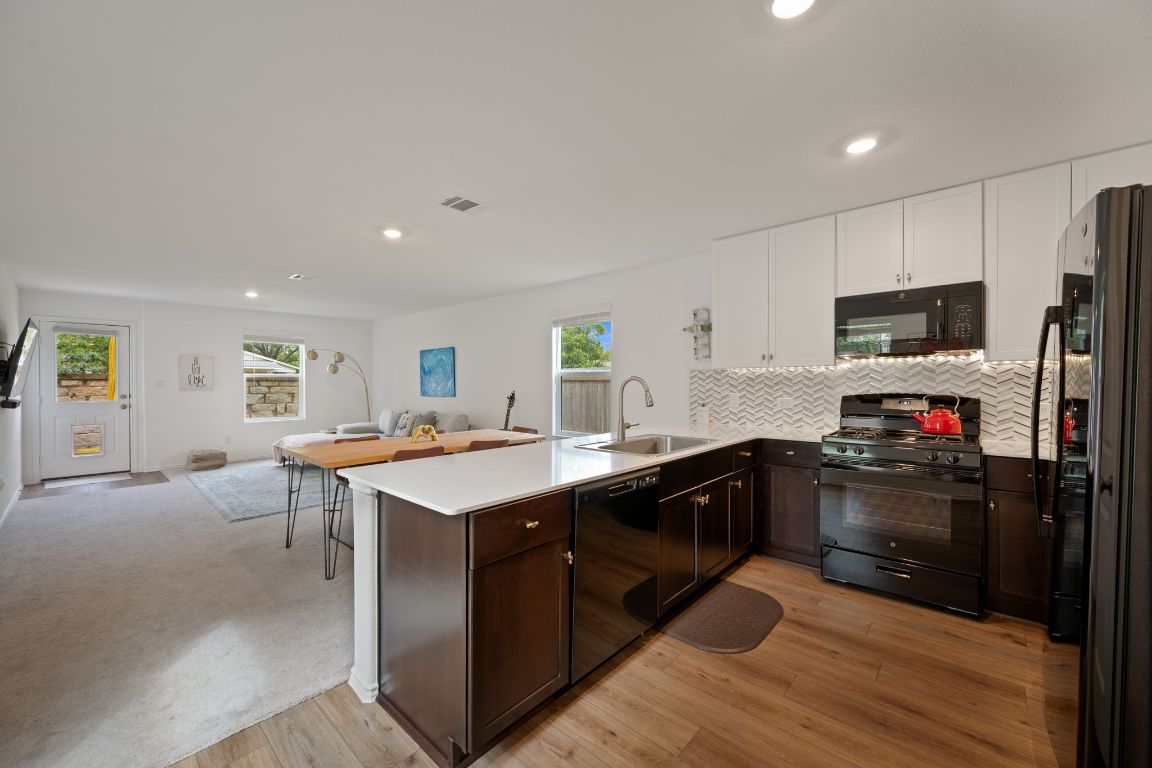 68 Trinity Circle Lockhart, TX 78644 - Photo 26 of 27 a kitchen with refrigerator cabinets and wooden floor