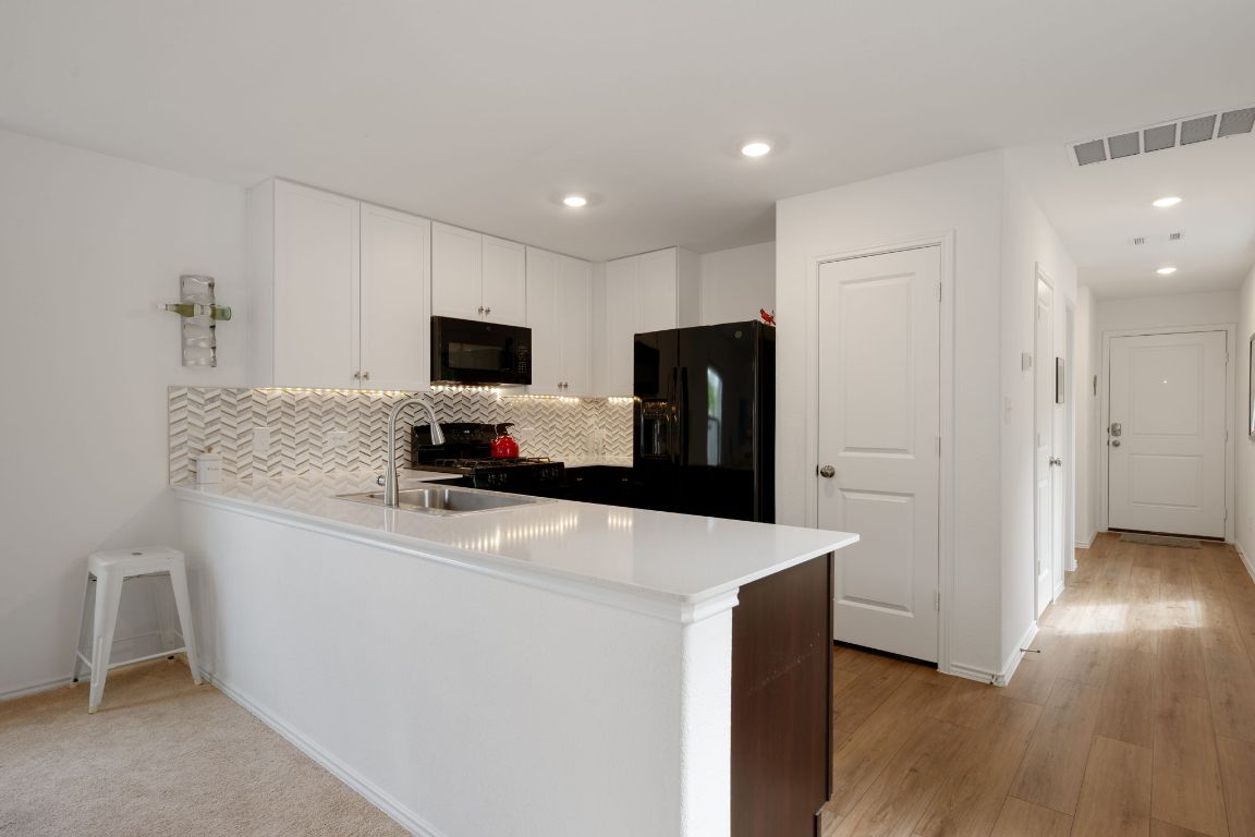 68 Trinity Circle Lockhart, TX 78644 - Photo 8 of 27 a kitchen with stainless steel appliances a refrigerator and a stove top oven