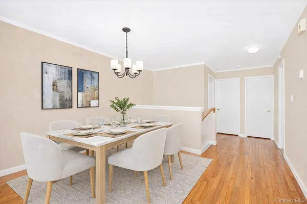 a dining room with furniture a chandelier and wooden floor