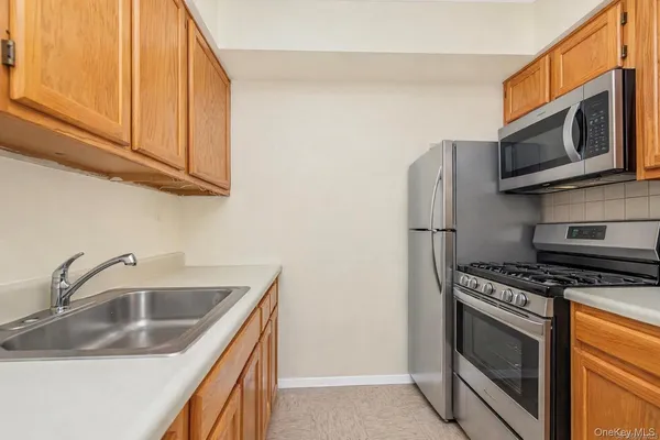 a kitchen with stainless steel appliances granite countertop a sink stove and microwave
