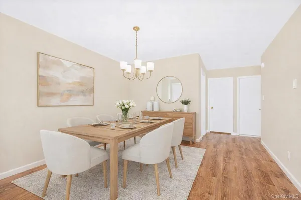 a view of a dining room with furniture wooden floor and chandelier