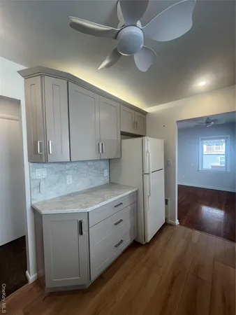 a kitchen with cabinets and wooden floor