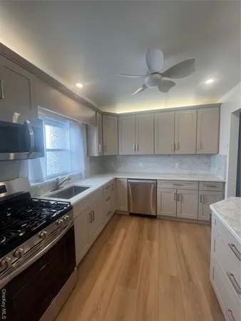 a kitchen with granite countertop a stove a sink and a refrigerator