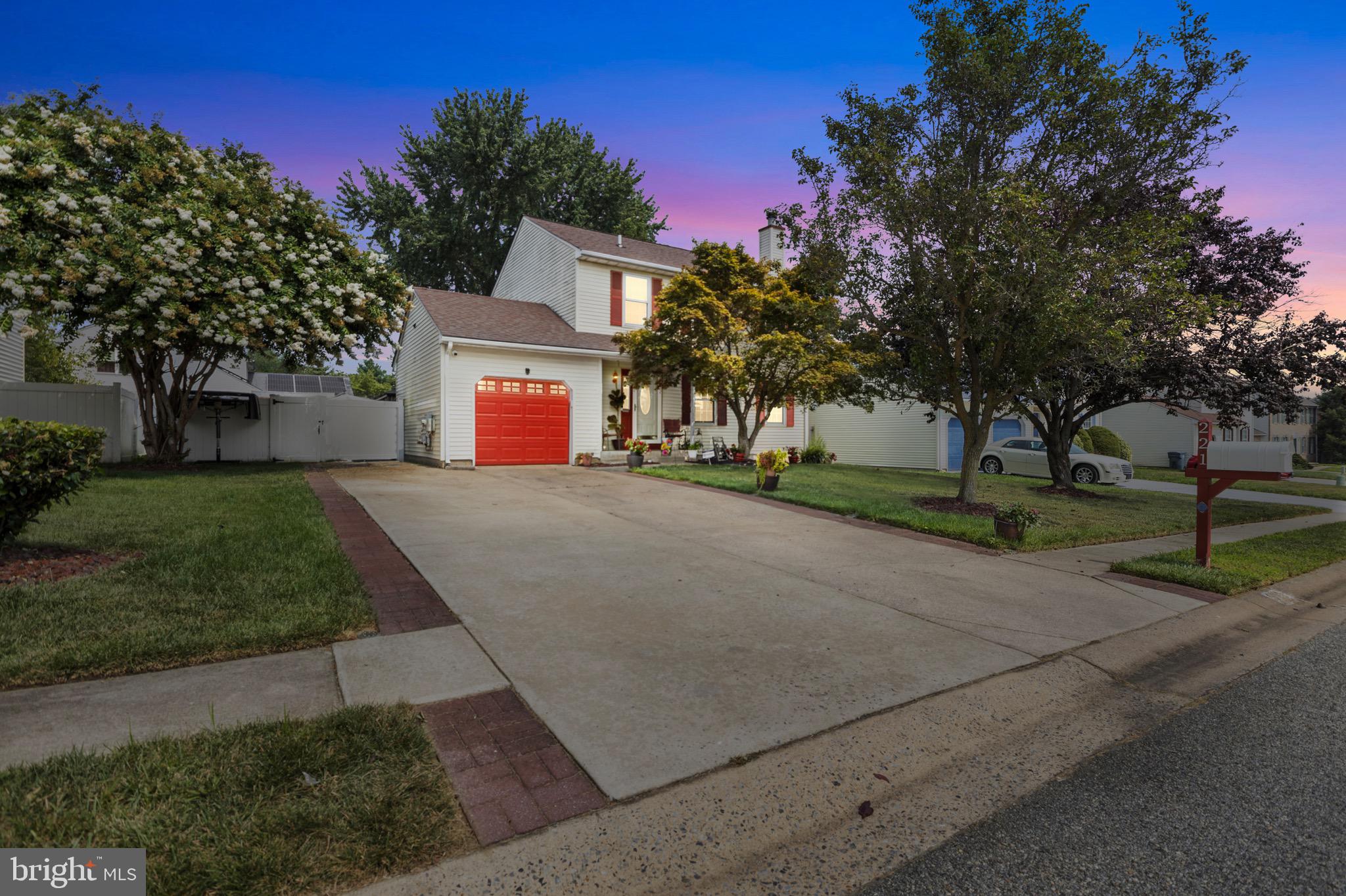 a front view of a house with a yard and tree