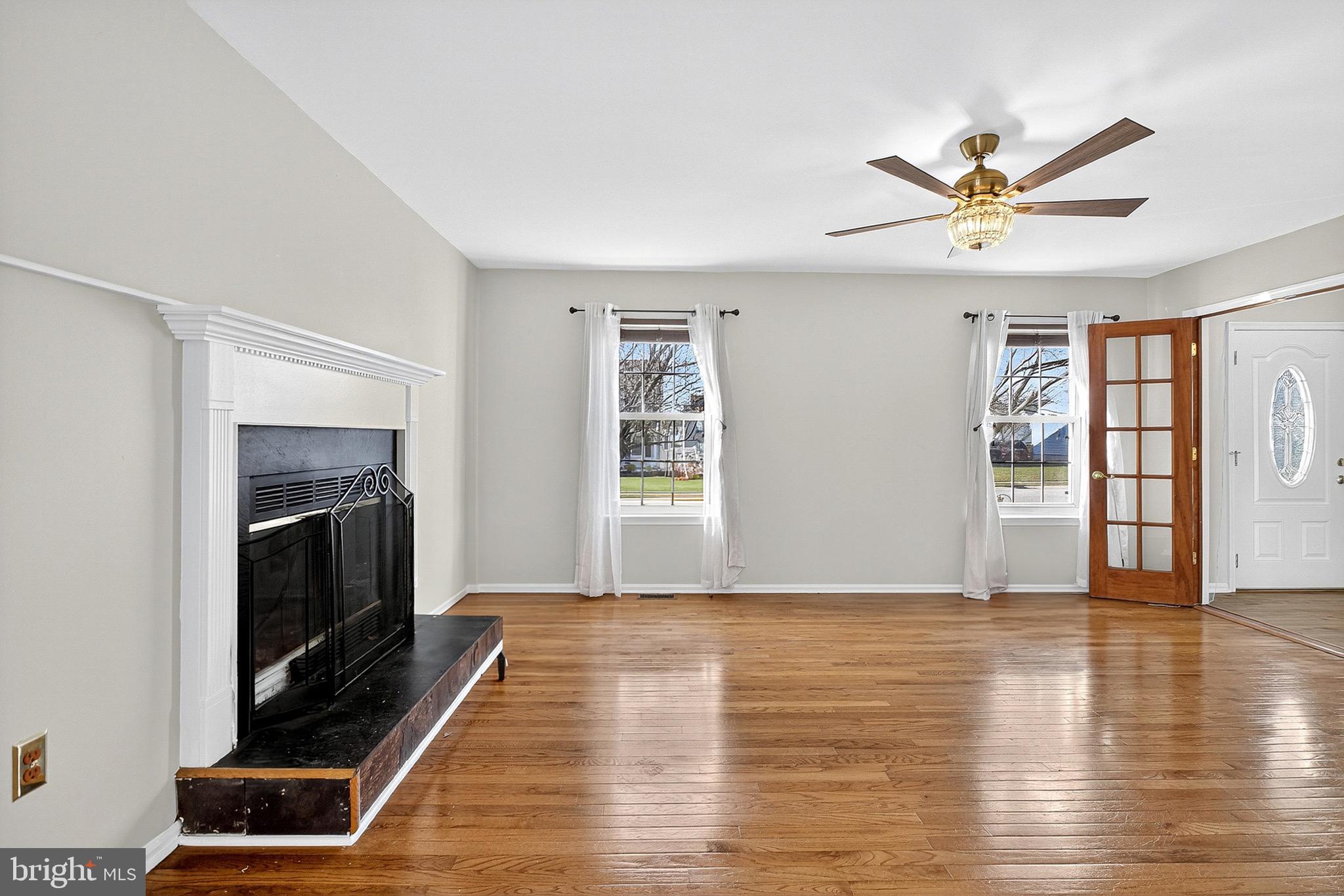 221 Romeo Drive New Castle, DE 19720 - Photo 11 of 38 a view of an empty room with wooden floor fireplace and a window