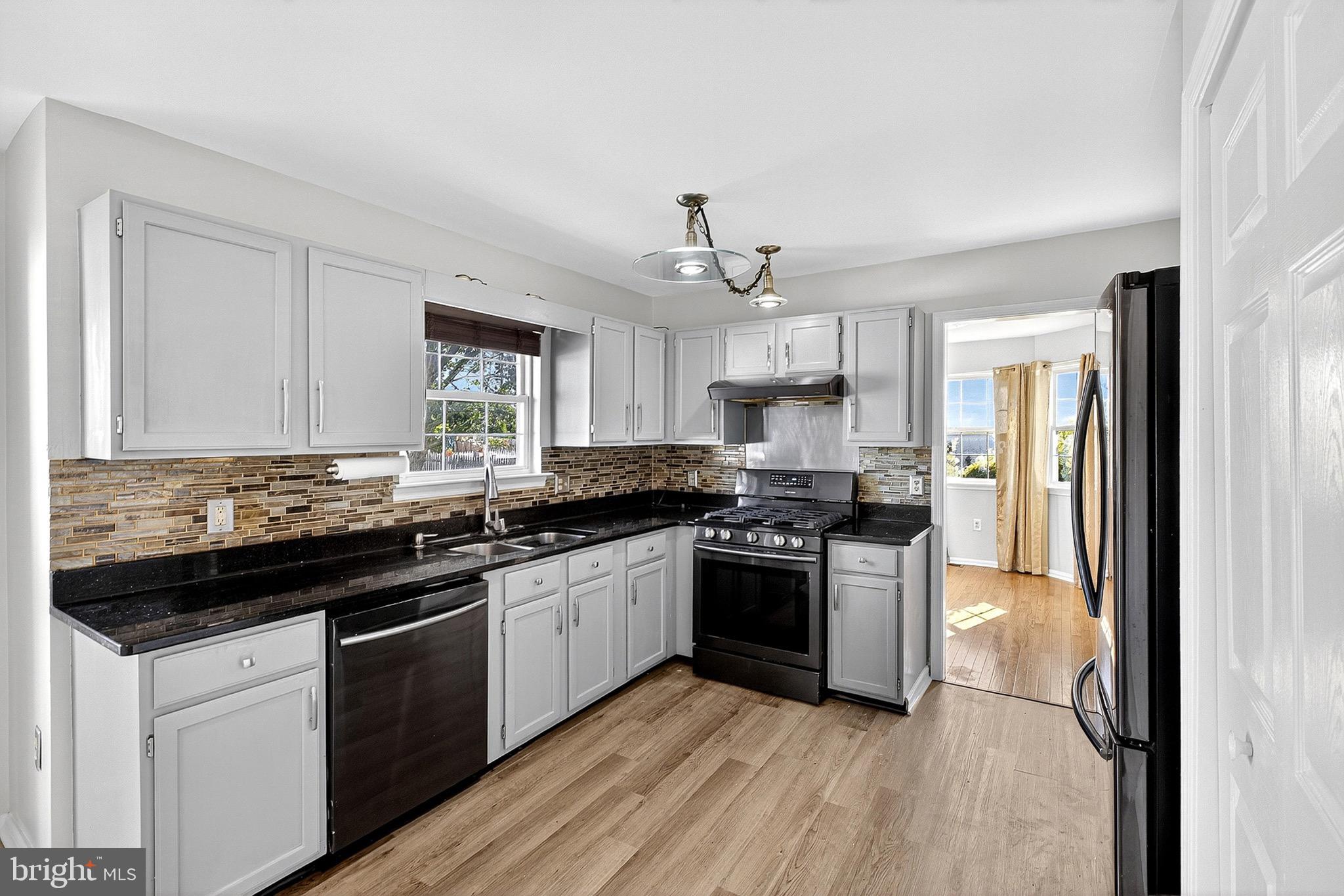 221 Romeo Drive New Castle, DE 19720 - Photo 17 of 38 a kitchen with stainless steel appliances granite countertop a stove and a sink