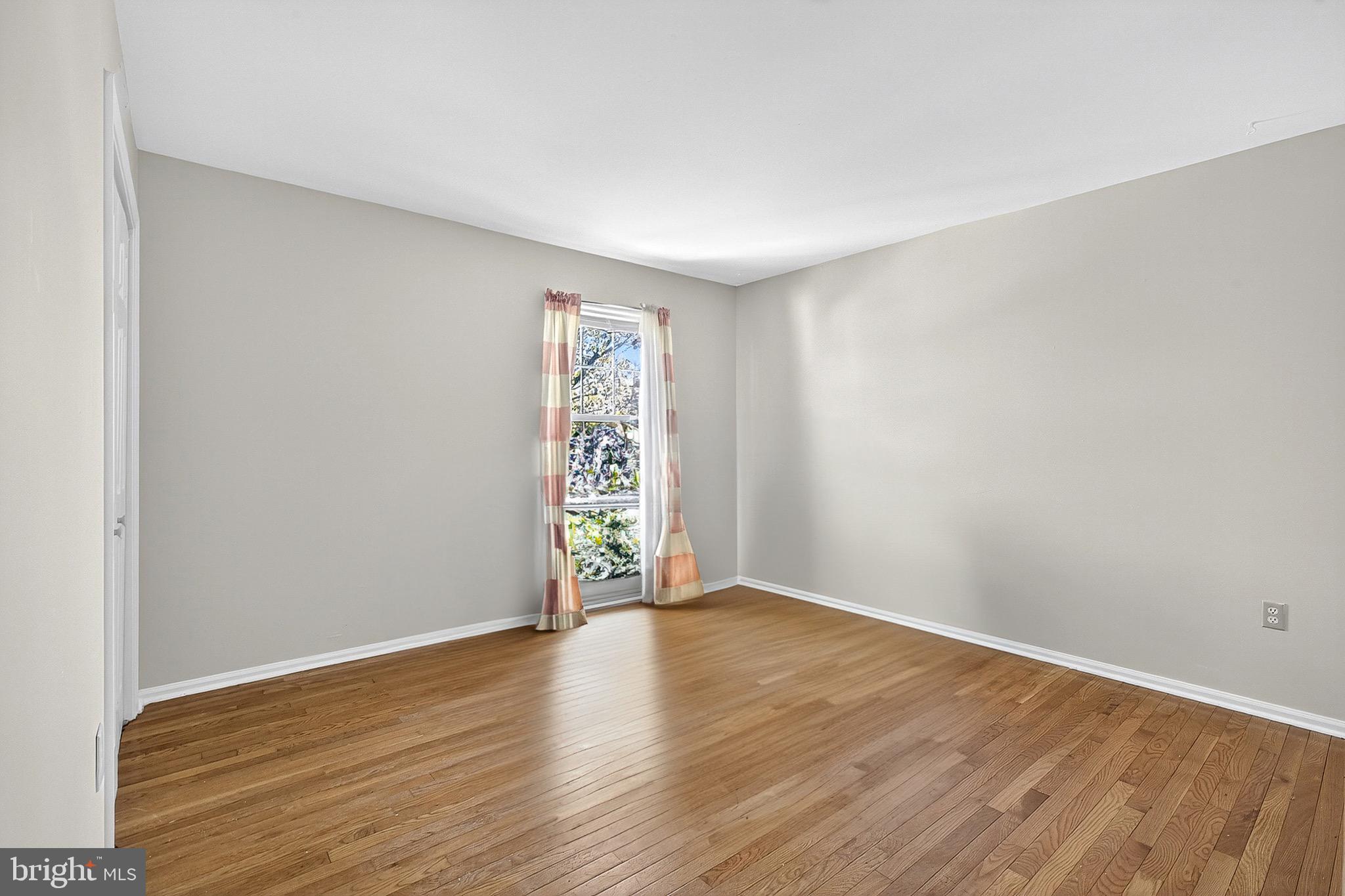 221 Romeo Drive New Castle, DE 19720 - Photo 30 of 38 a view of an empty room with wooden floor and a window