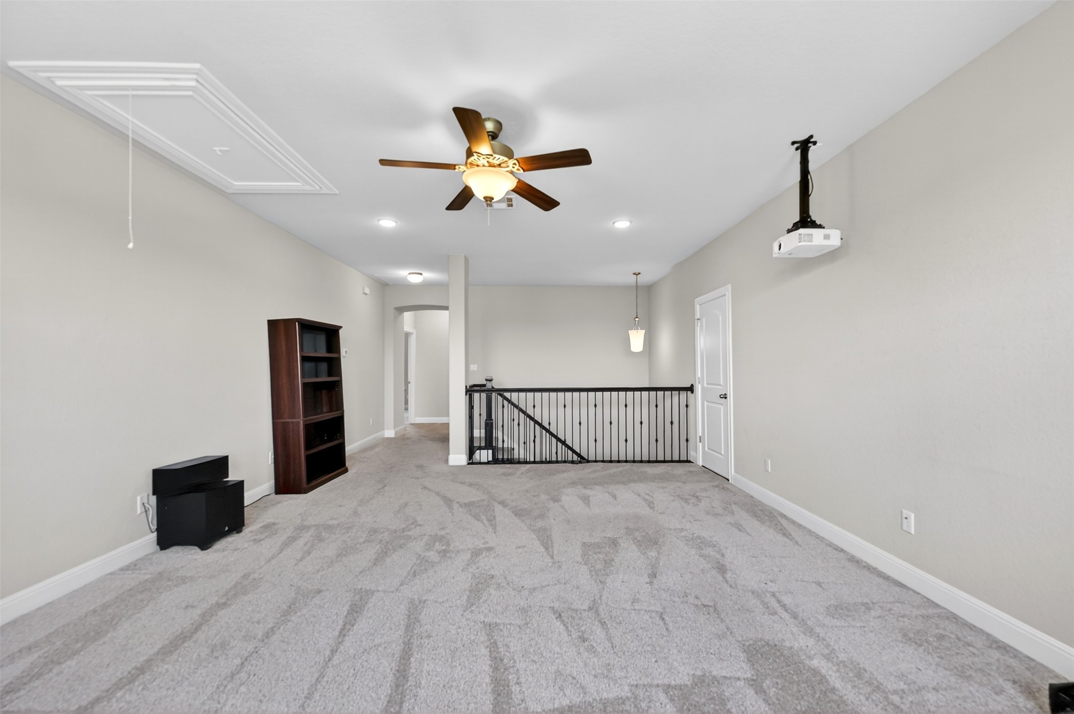1201 Positano Pass Leander, TX 78641 - Photo 35 of 40 Spacious upper-level room featuring light gray carpeting, a ceiling-mounted projector, and a ceiling fan with integrated lighting