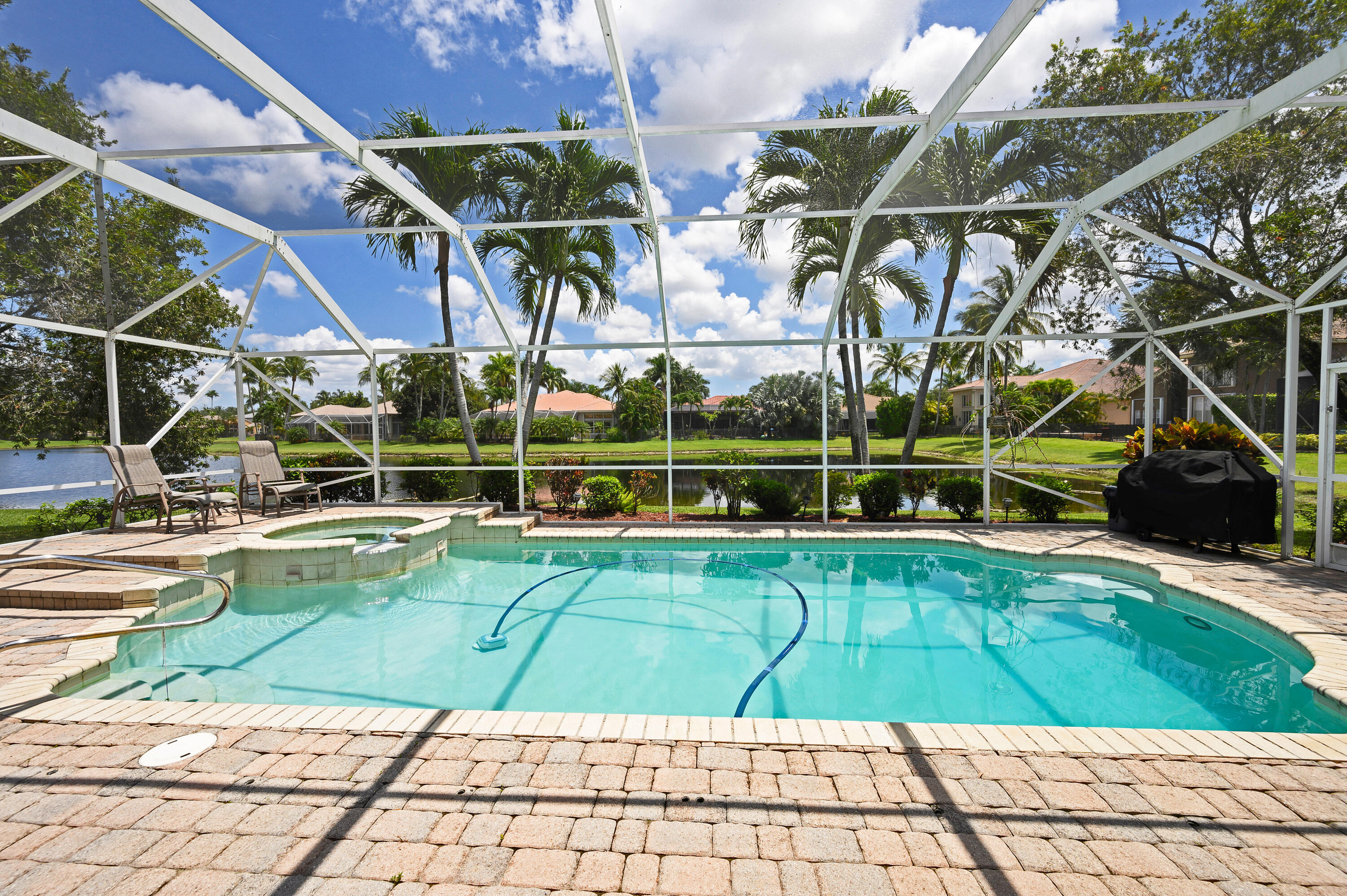11840 Bayfield Drive Boca Raton, FL 33498 - Photo 12 of 28 a view of a swimming pool with a bench and lawn chairs