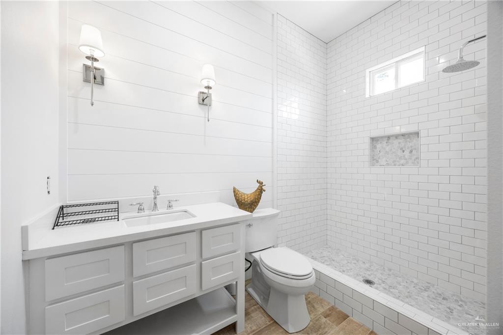 2860 North Fm 2360 Rio Grande City, TX 78582 - Photo 17 of 32 a bathroom with a granite countertop toilet a sink a mirror and shower