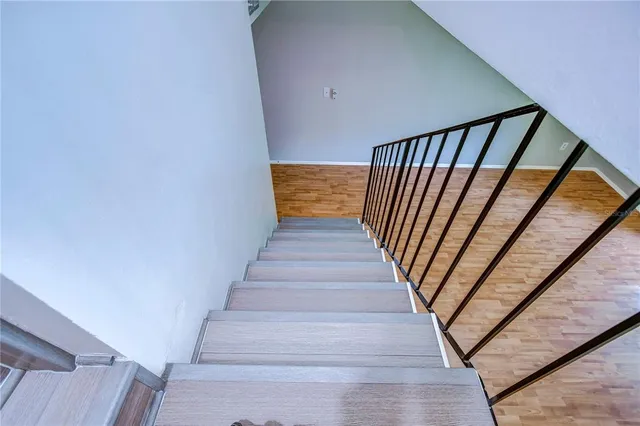 a view of staircase with wooden floor and white walls