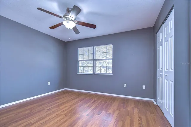 a view of an empty room with window and wooden floor