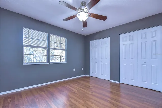 a view of an empty room with window and wooden floor