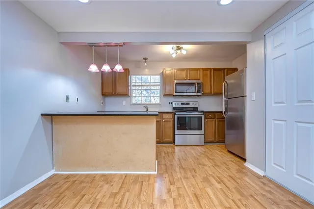 a kitchen with stainless steel appliances a refrigerator and a stove top oven