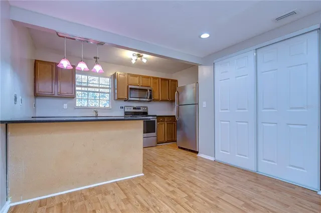 a kitchen with stainless steel appliances granite countertop a stove a sink and a refrigerator