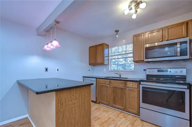 a kitchen with stainless steel appliances a stove sink microwave and cabinets