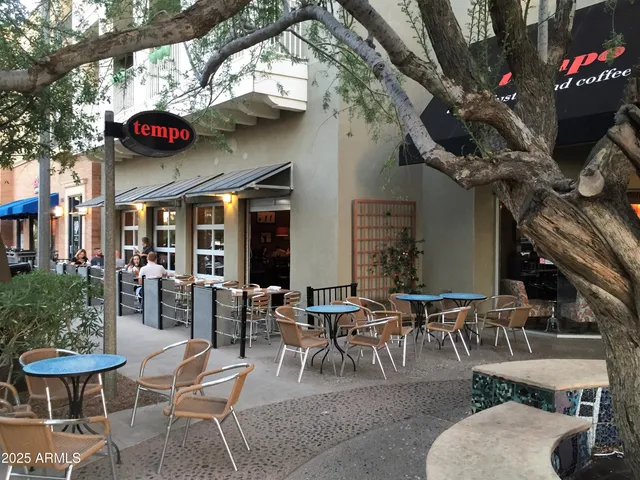a view of a patio with table and chairs potted plants and a large tree
