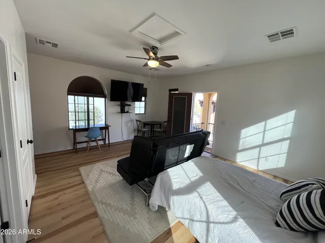 a living room with furniture large window and wooden floor