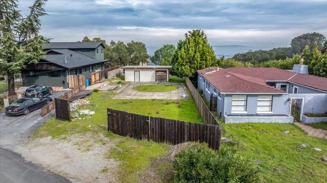 a view of a backyard with wooden fence