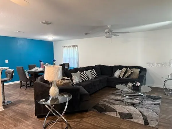a living room with furniture and wooden floor