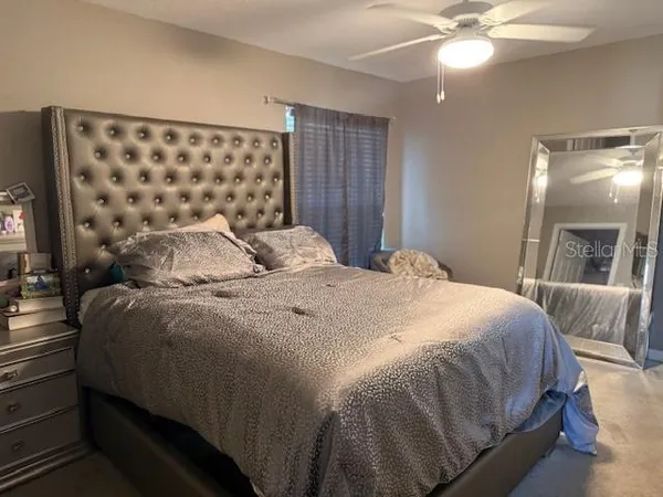 a bedroom with a large bed and a chandelier