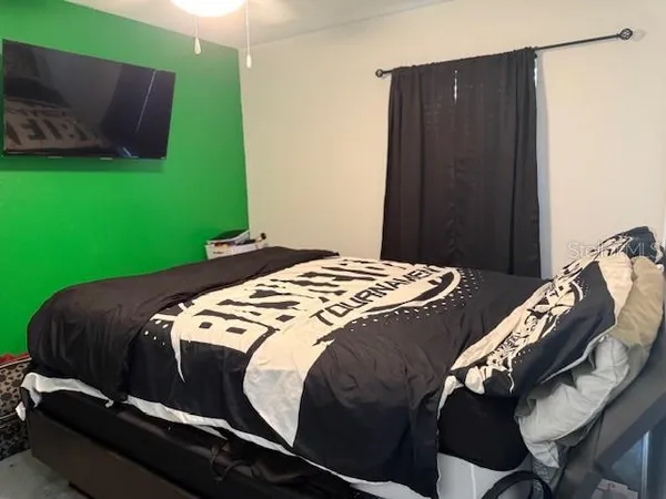 a bedroom with a bed and a television