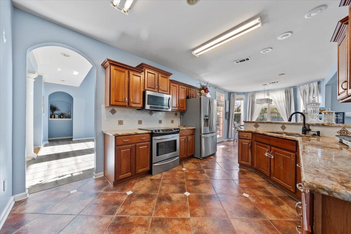 10941 Lubov Road Arlington, TN 38002 - Photo 10 of 39 a large kitchen with stainless steel appliances granite countertop a stove sink and cabinets