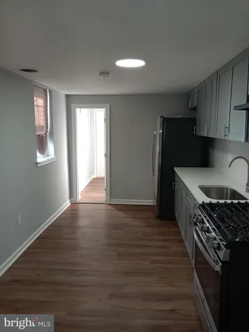 a kitchen with granite countertop wooden cabinets a sink and a stove