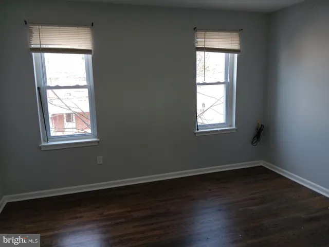 an empty room with wooden closet and windows