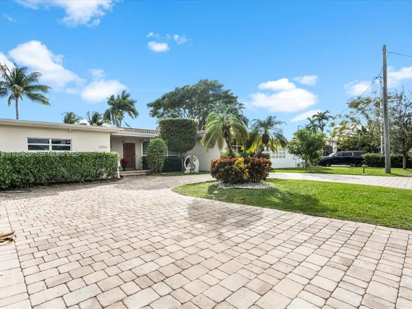 a front view of a house with a yard and potted plants